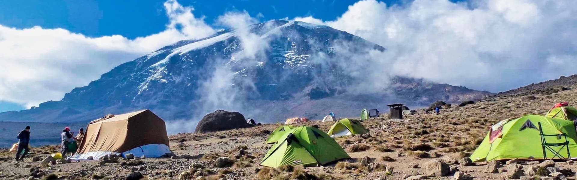 Tents pitched on a rocky camp beneath Kibo
