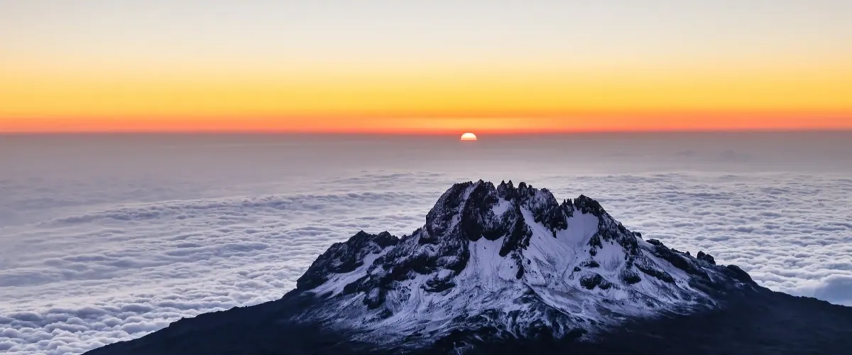Mountain peak rising above the clouds at sunrise